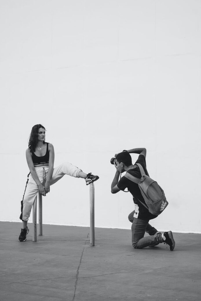 monochrome photography of person taking photo of a woman