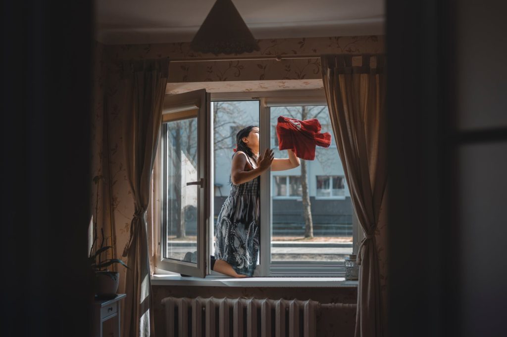 woman cleaning a glass window