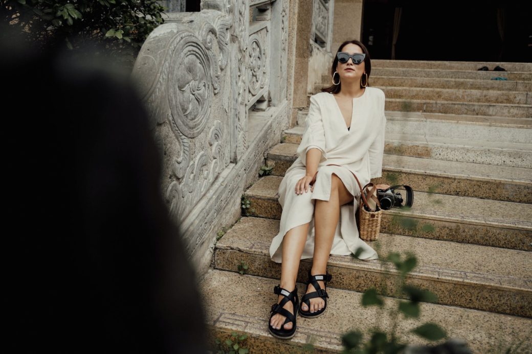 woman in white dress and black sandals posing on stairs