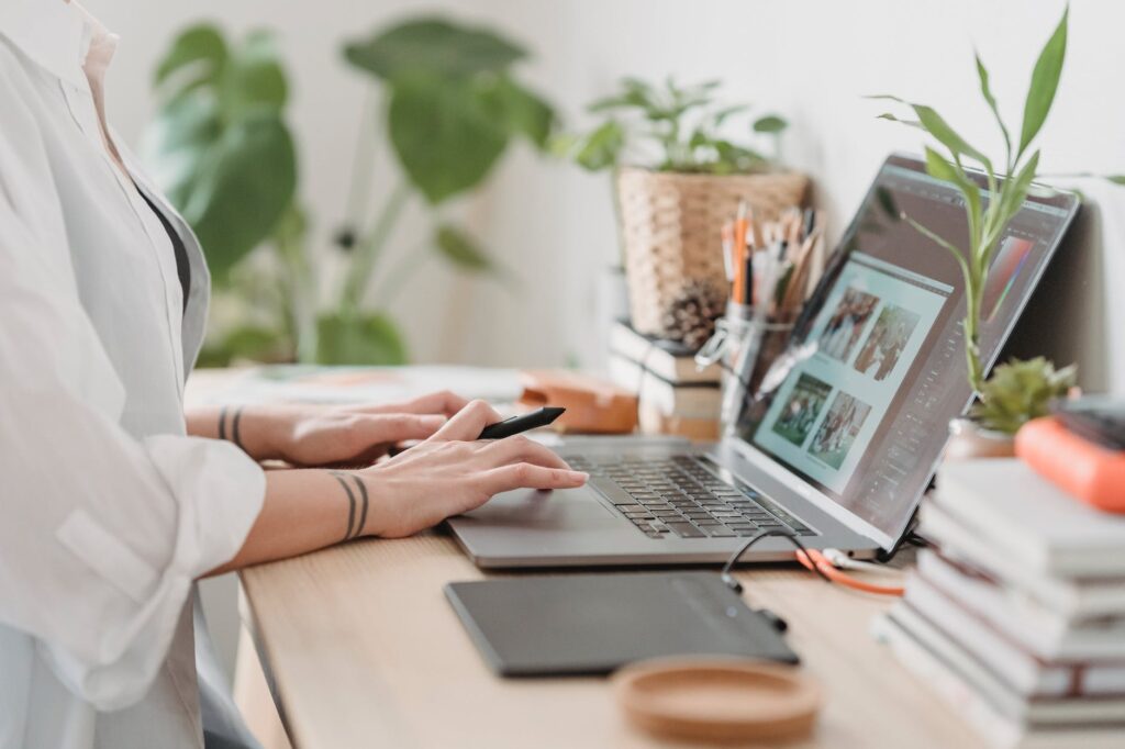 woman working retouching photo on laptop at convenient workplace