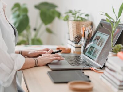 woman working retouching photo on laptop at convenient workplace